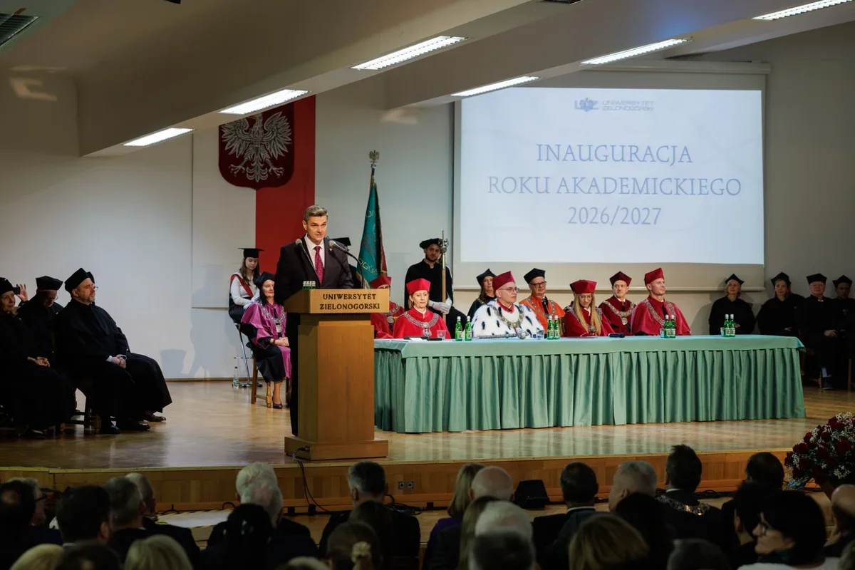 Mężczyzna w garniturze przemawia z pulpitu podczas inauguracji roku akademickiego 2026/2027 na Uniwersytecie Zielonogórskim, za stołem zasiadają osoby w togach