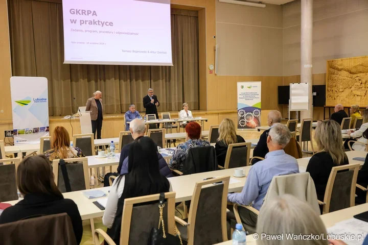 Uczestnicy konferencji w sali wykładowej słuchają prelegentów przygotowujących prezentację o GKRPA w praktyce.