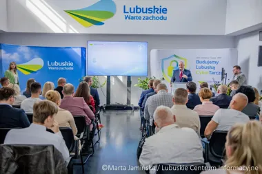 Konferencja w siedzibie Lubuskiego Centrum Informacyjnego: mówca przemawia do publiczności przy banerach promujących województwo lubuskie i cyberbezpieczeństwo.